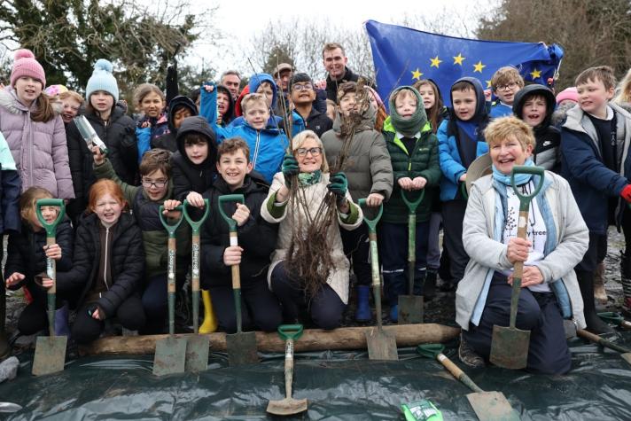 Tree planting event in Kilternan on 4 March 2024 - Commissioner McGuinness with pupils and teachers from C of I Kilternan NS, Ambassadors of EU countries and European Commission staff
